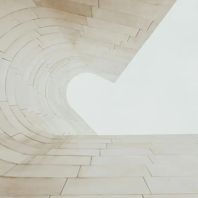 a white stone wall with a curved arch