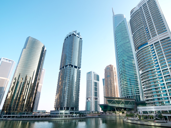 a group of tall buildings next to a body of water